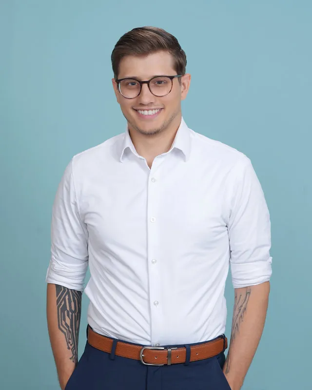 Ventures smiling in a white shirt against a light-blue backdrop